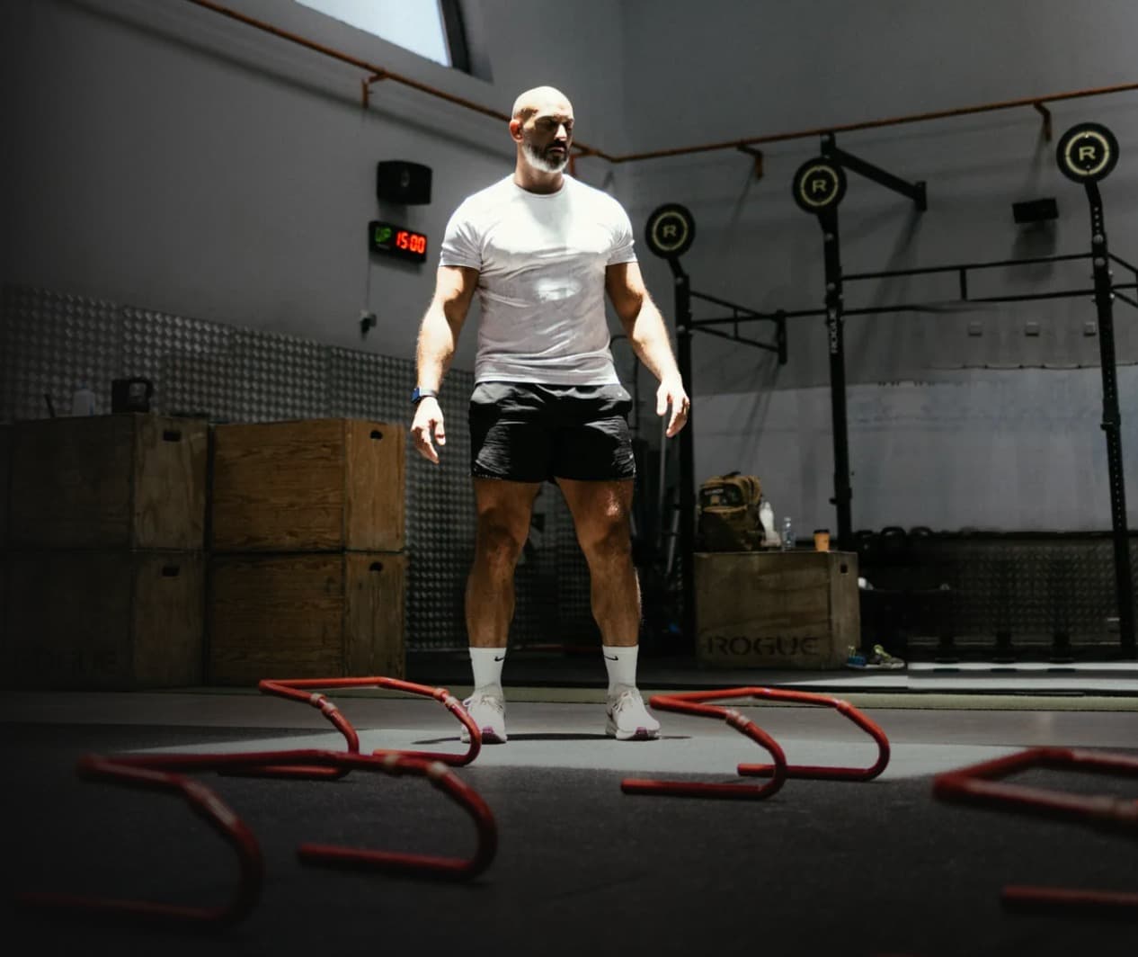 Coach in a gym with training hurdles